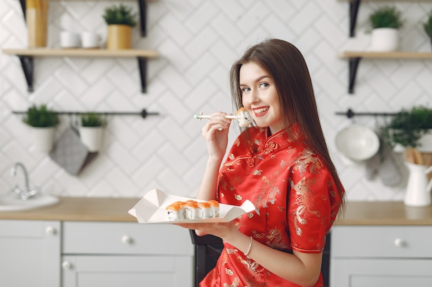 Girl sitting at home at the table with a sushi