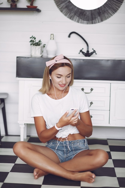 Free photo girl sitting at home and use the phone