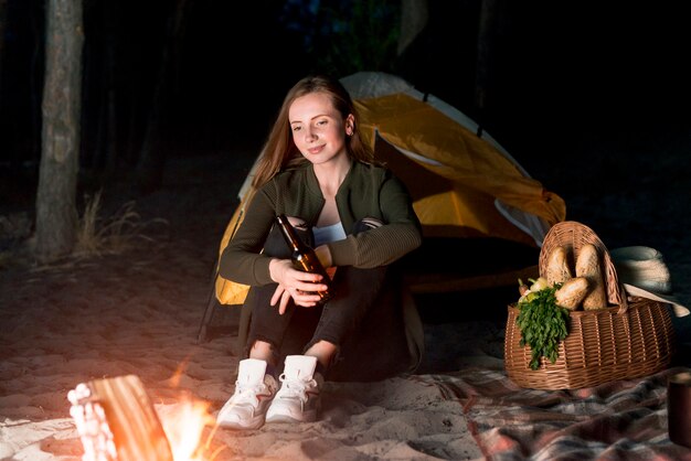 Girl sitting and looking at bonfire