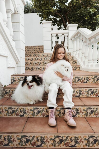 Girl sitting outdoors with her dogs