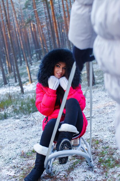 girl sitting on a sledge in the winter forest