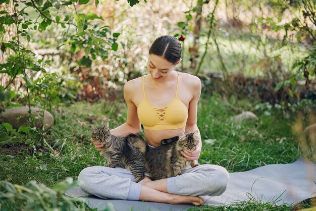 かわいい猫と夏の公園に座っている女の子