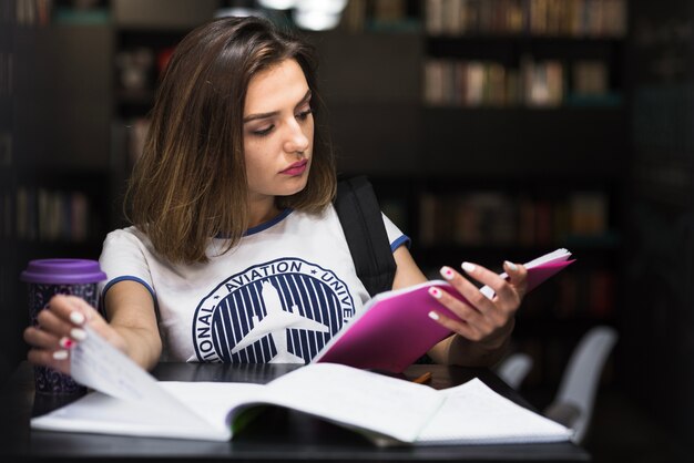 Girl sitting at table reading flipping page