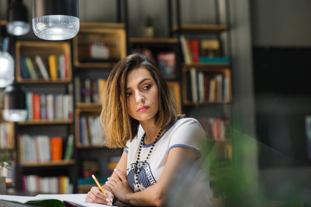 Girl sitting at table with notebooks writing