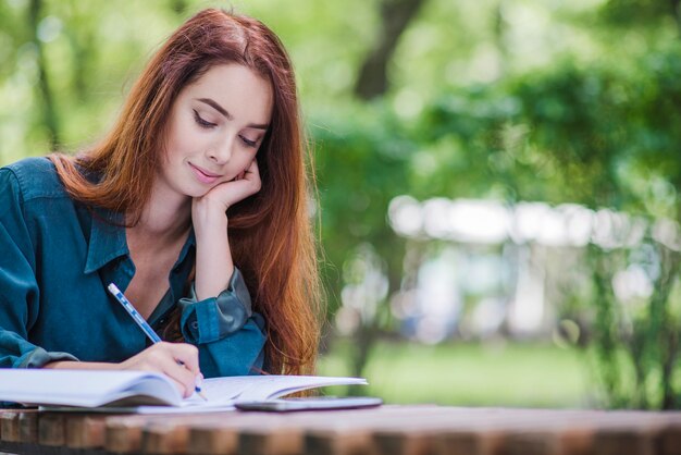 Girl sitting at table writing