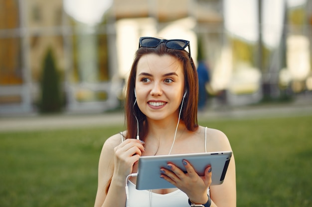 タブレットを使用して大学のキャンパスに座っている女の子