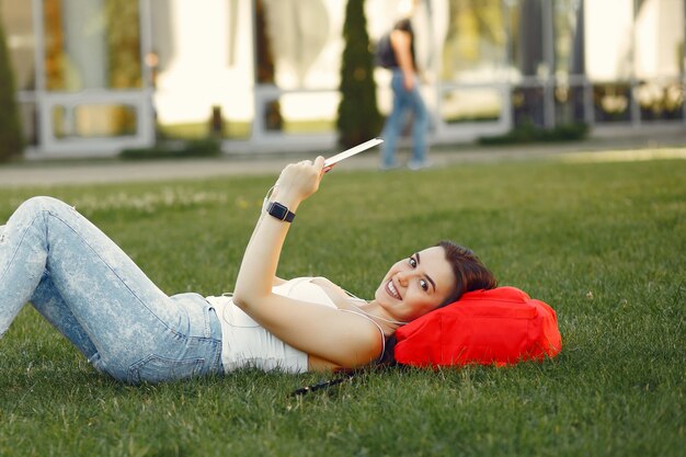 Girl sitting in a university campus using a tablet