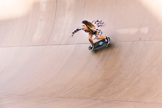 Girl skating in half pipe