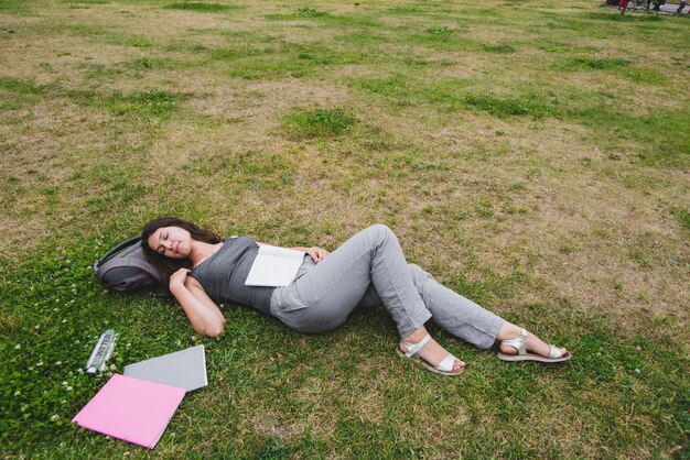 公園の草の上で眠っている少女