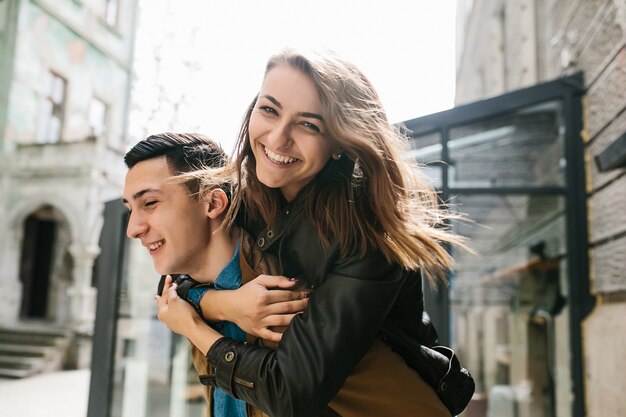 Ragazza che sorride sulla schiena del suo ragazzo