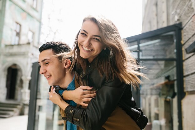 Girl smiling on her boyfriend's back
