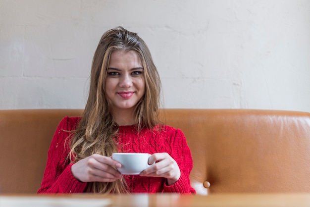 Free photo girl smiling and holding a cup