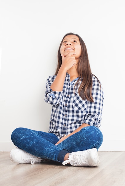 Girl smiling pensively with hand on chin