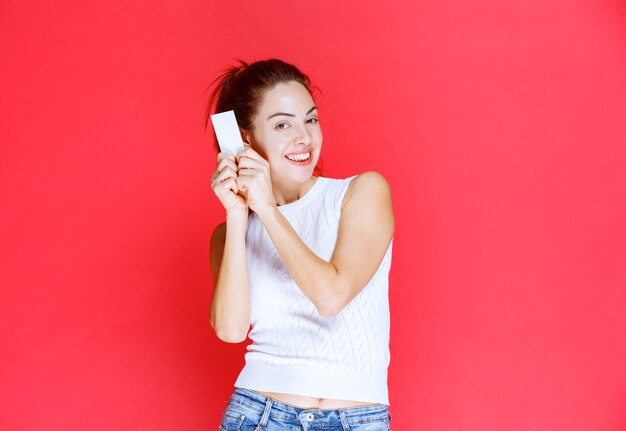 Girl smiling and presenting her business card. 