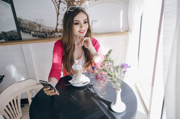 Girl smiling while holding her phone with one hand