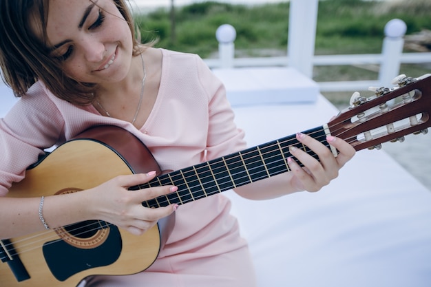 Girl smiling while playing the guitar