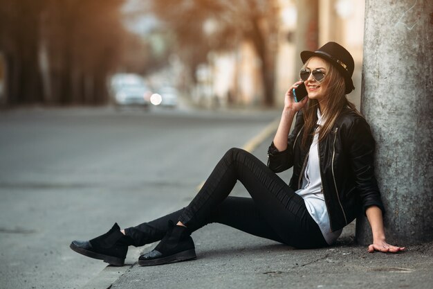 Girl smiling while talking on her mobile sitting on the floor