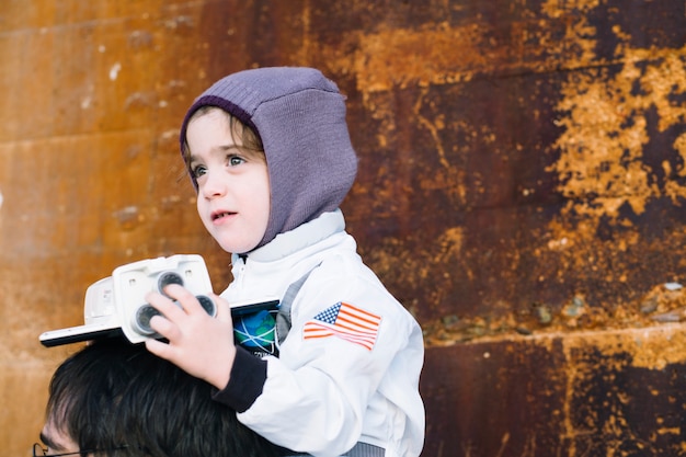 Free photo girl in spacesuit sitting on father