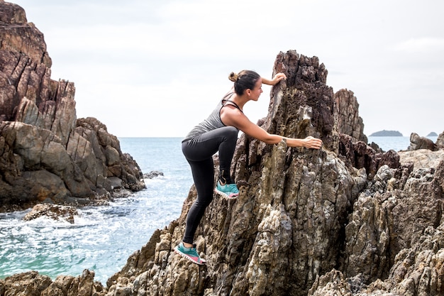 The girl in sportswear on the rocks