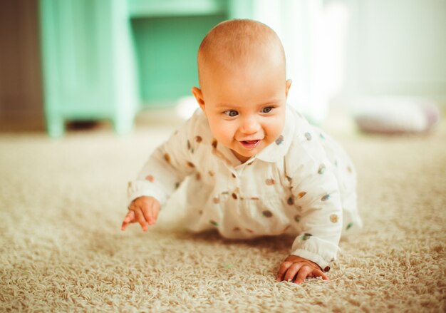 Girl in spotted shirt sits on fluffy carpet