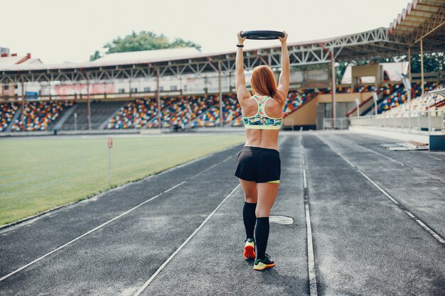 The girl at the stadium is playing sports