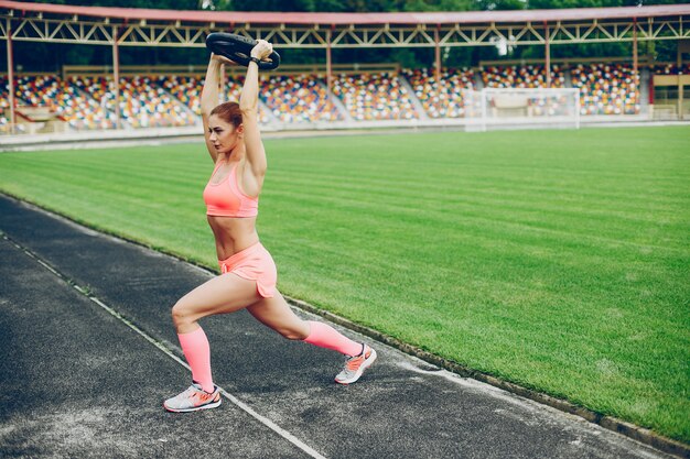 The girl at the stadium is playing sports