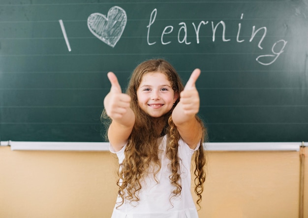 Girl standing at blackboard in class