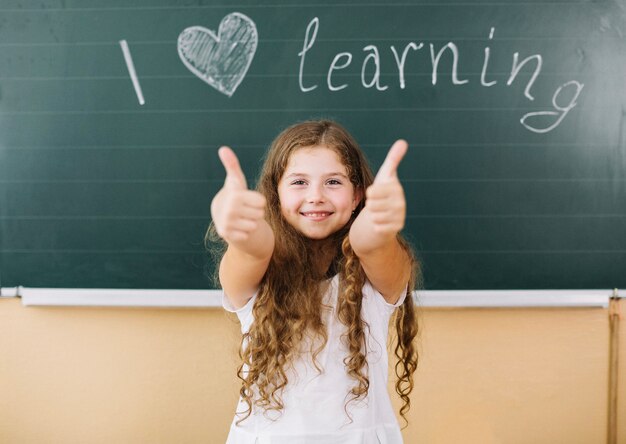 Girl standing at blackboard in class