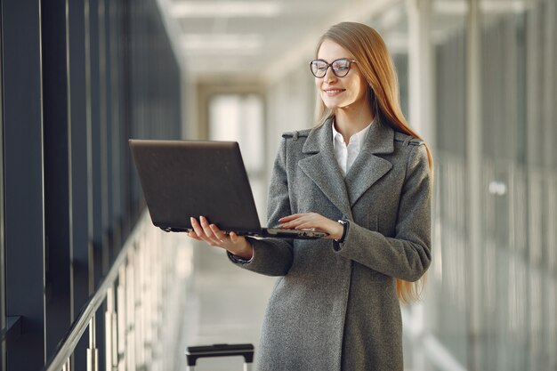 Girl standing in the office with a laptop