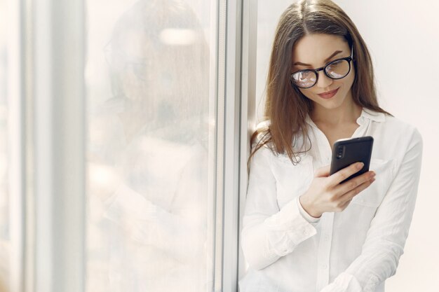 Girl standing in the office with a phone