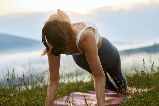 Free photo girl standing in plank in mountains