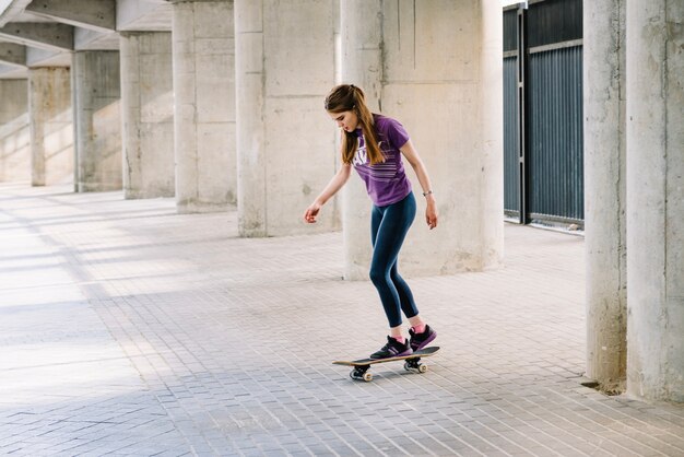 女の子、スケートボードに立つ