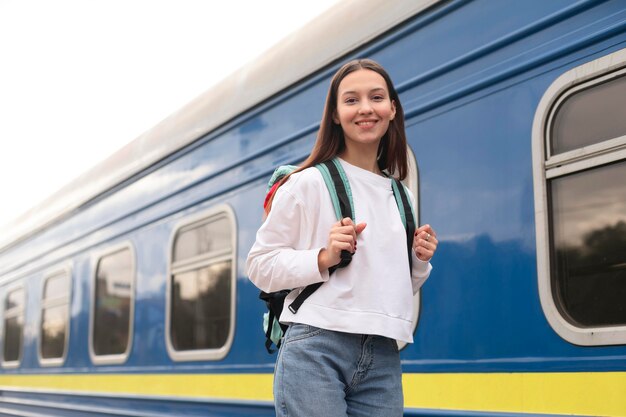 Ragazza in piedi accanto alla vista bassa del treno