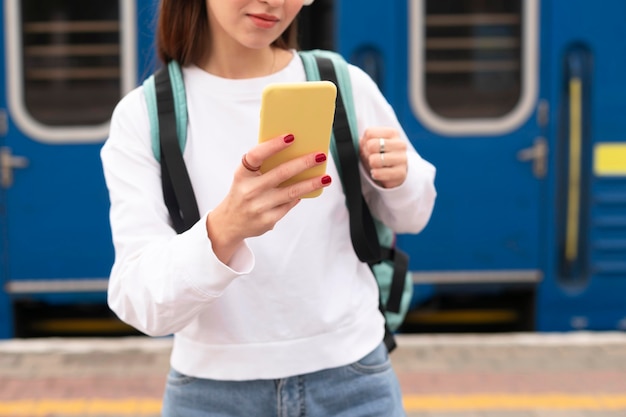 Foto gratuita ragazza in piedi accanto al colpo medio del treno