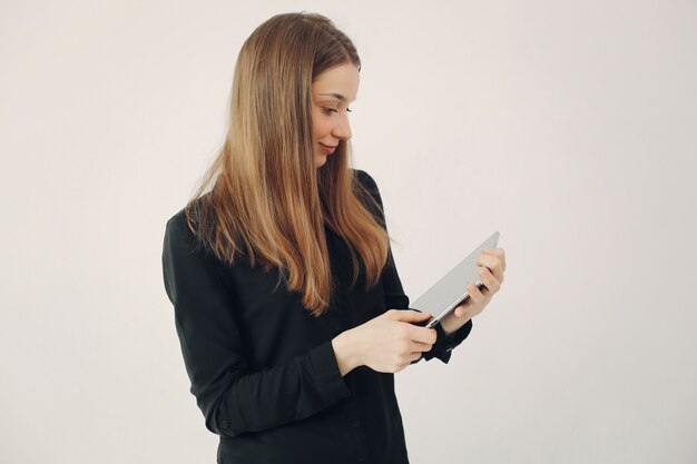 Girl standing on a white wall with a laptop