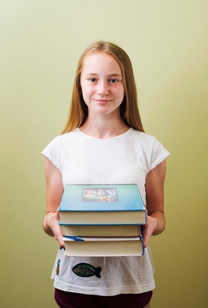 Girl standing with books stack