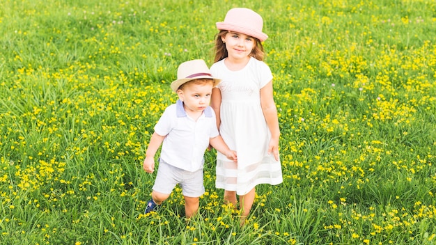 Girl standing with her brother in meadow