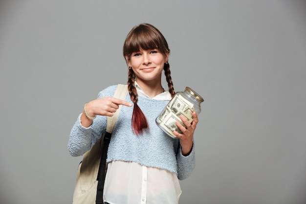 Girl standing with jar full of money