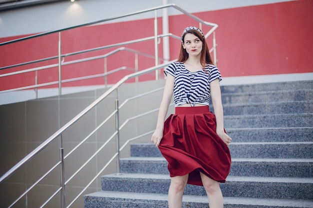 Free photo girl in a stands holding her red skirt