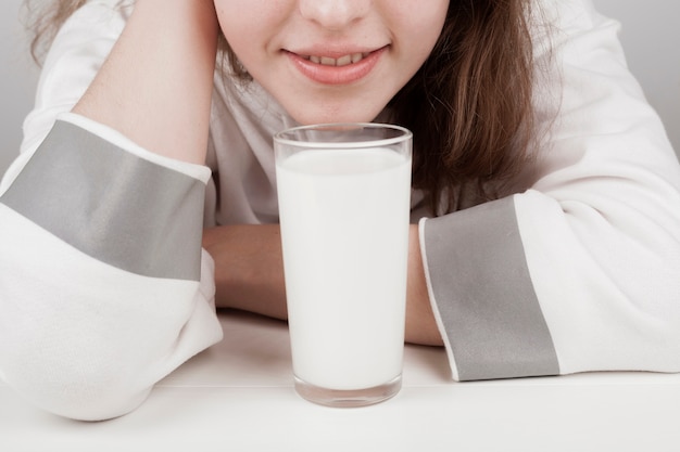 Foto gratuita ragazza stare accanto a un bicchiere di latte