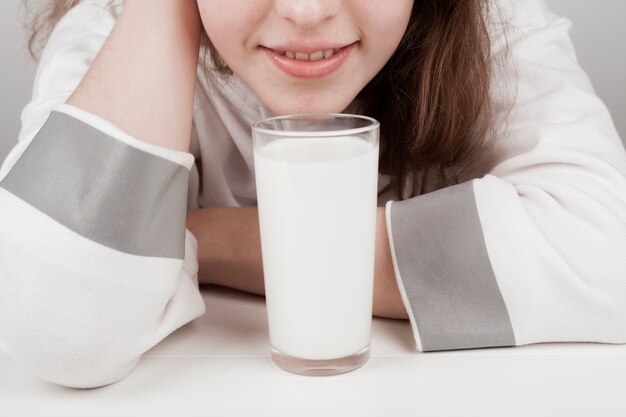 ミルクのガラスの隣に滞在する女の子