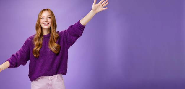 Girl stretched hands sideways to welcome and greet friend giving warm hug smiling broadly at camera