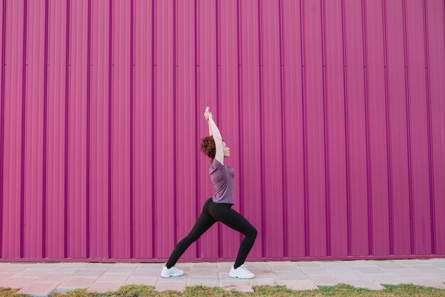 Girl stretching on street with hadns up