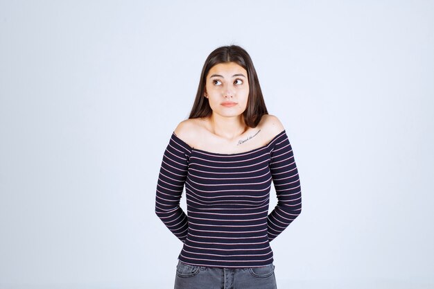 Girl in striped shirt giving neutral poses without reactions. 