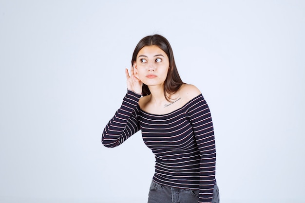 Girl in striped shirt listening or doing gossip. 