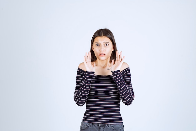 Girl in striped shirt looks terrified and scared. 