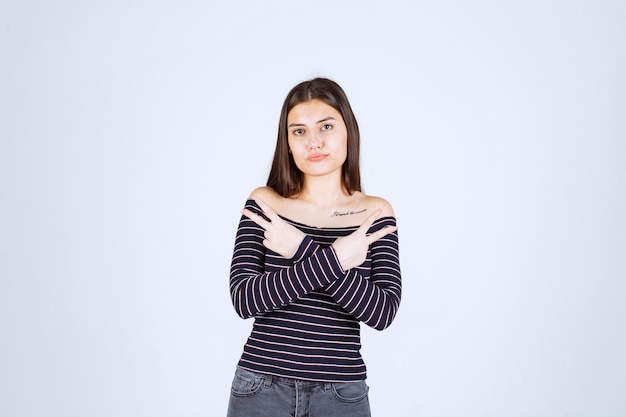 Girl in striped shirt pointing to the side. 