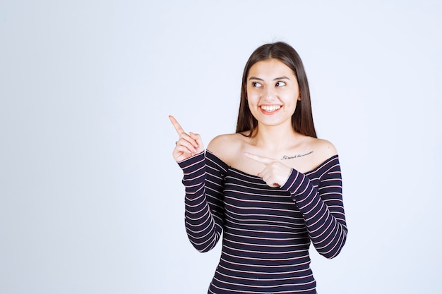 Foto gratuita ragazza in camicia a righe rivolta verso l'alto e mostrando emozioni.