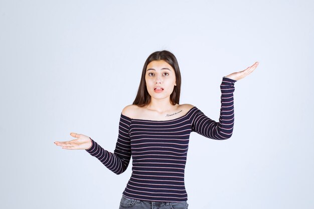 Girl in striped shirt pointing up and showing emotions. 