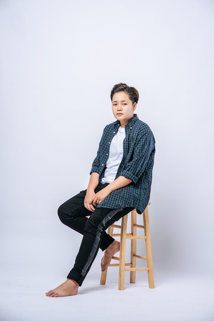 A girl in a striped shirt sitting on a high chair.